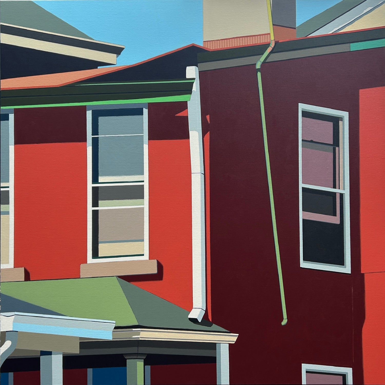 Colorful row houses with red and green accents on a clear day.