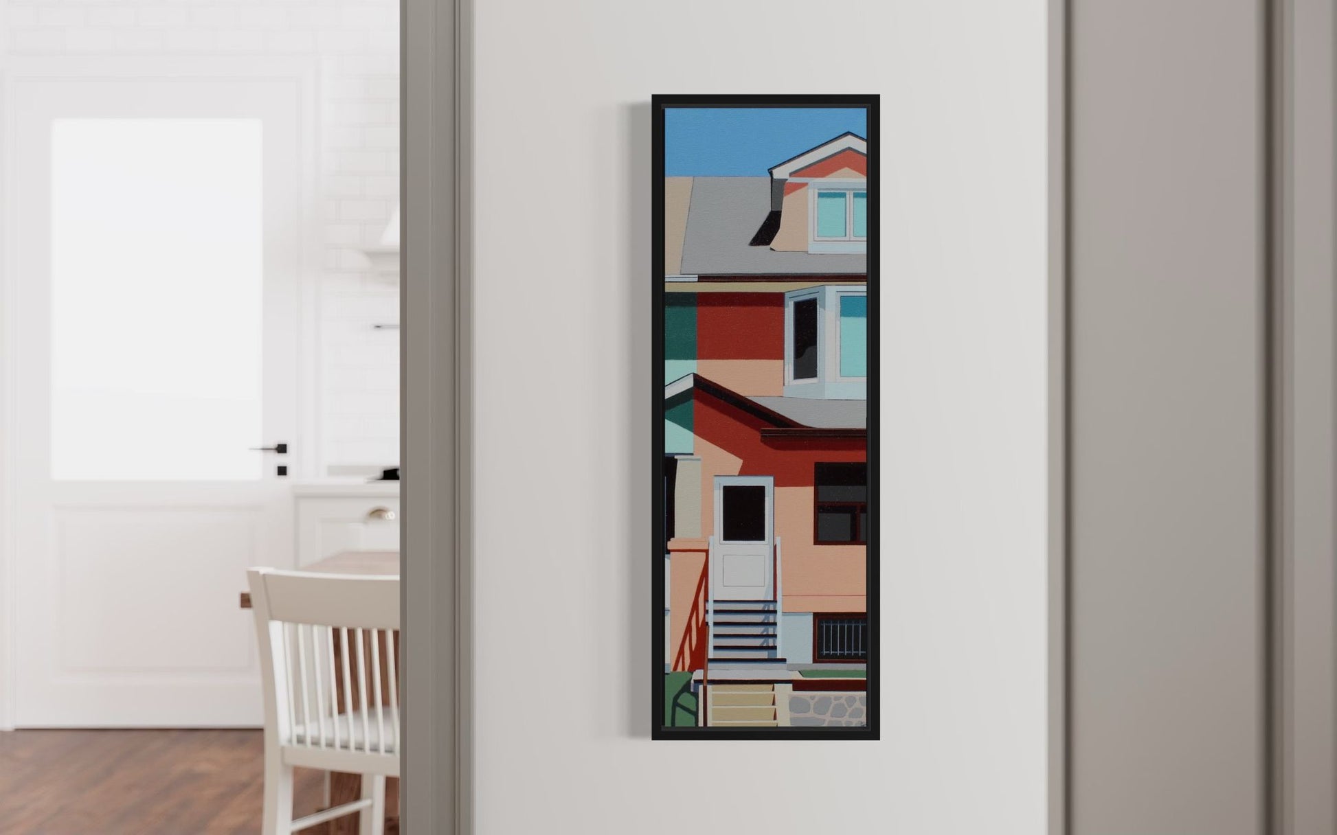 Framed abstract art piece on a wall in a room with a chair and table.